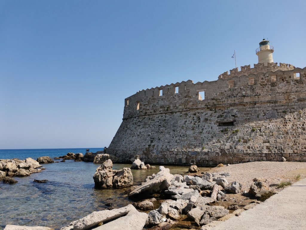 St Nicholas Fortress against the clear sea at Mandraki Port in Rhodes Town, Greece