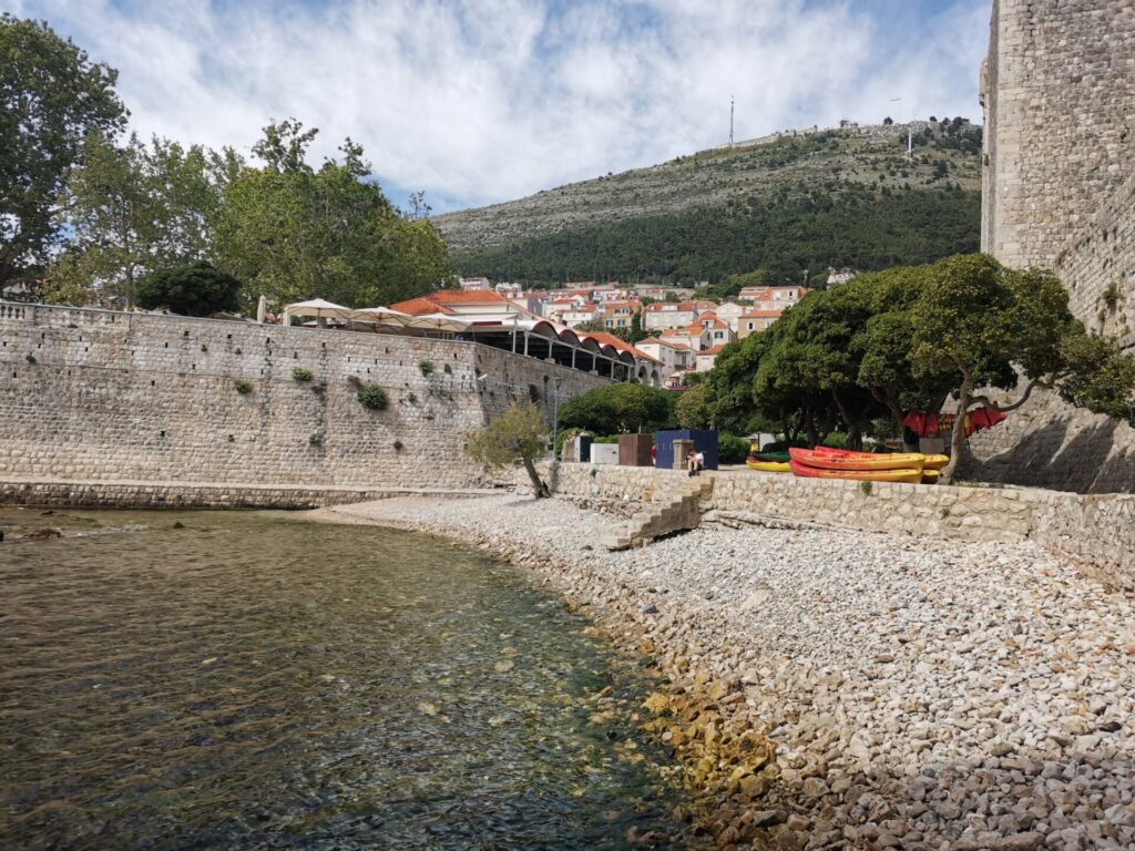 One of the small beaches in Dubrovnik with clear waters and kayaks for rent, a popular Dubrovnik attraction.