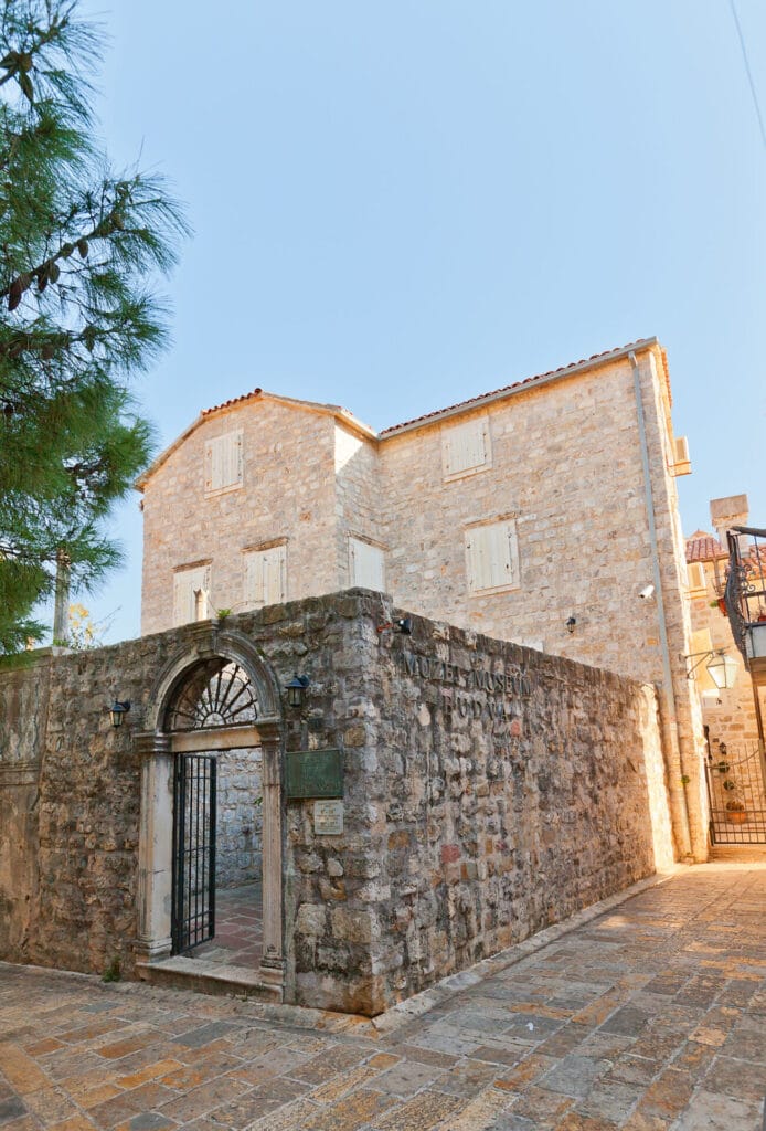 A corner view of the old building that is Budva Archealogical museum with a stone arched entrance in Budva Old Town, Montenegro