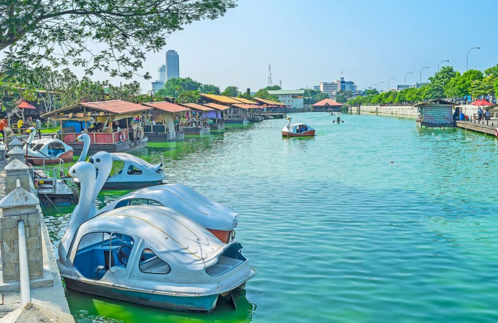 A sunny day on the lake with little boats and Pettah floating market in full action in Colombo, Sri Lanka