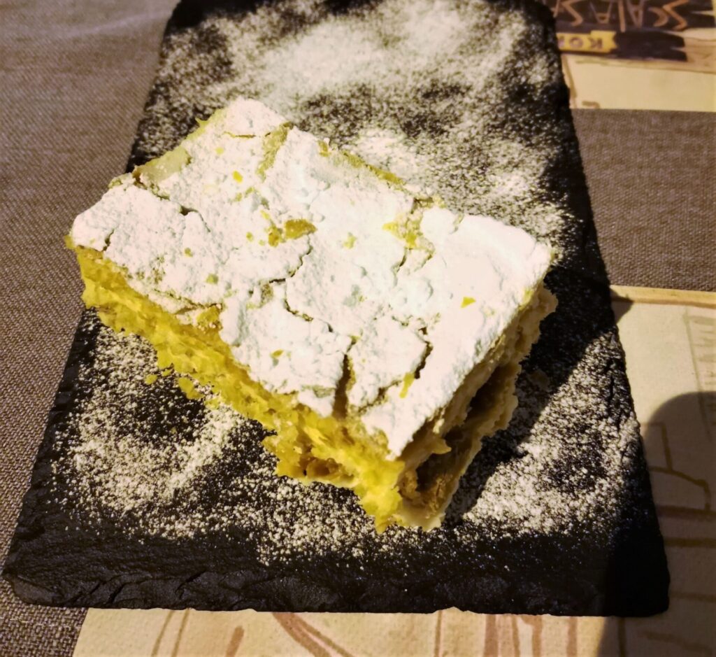 Montenegro food - Krempita dessert on a black slate plate sprinkled with caster sugar