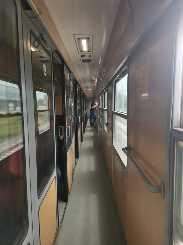 Corridor leading to train compartments with glass sliding doors on Sofia to Burgas train in Bulgaria