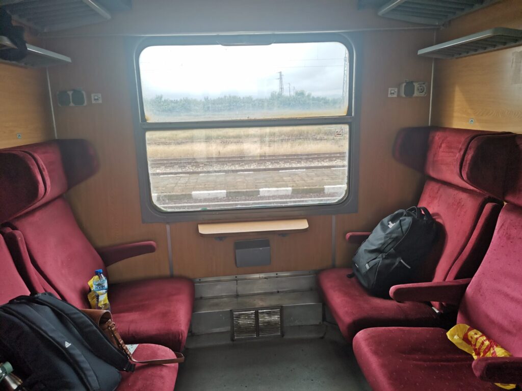 Seated compartment with 6 seats and red velvet upholstery on the Sofia to Burgas Bulgaria trains