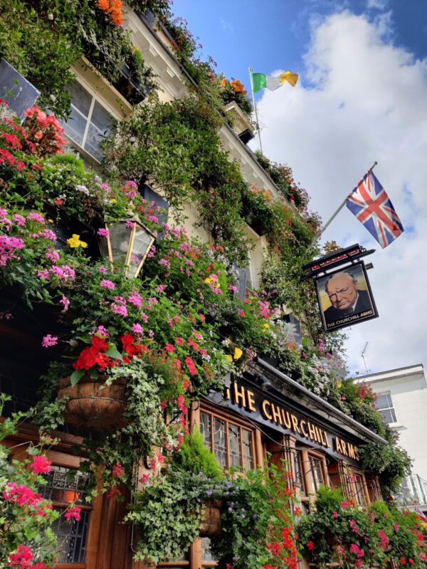 The Churchill arms covered with plants and flowers, celebrating british pubs