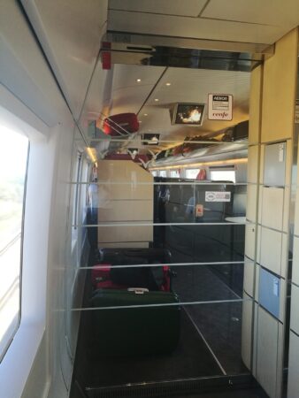 Madrid to Seville train, AVE train vestibule with glass door looking into seating area