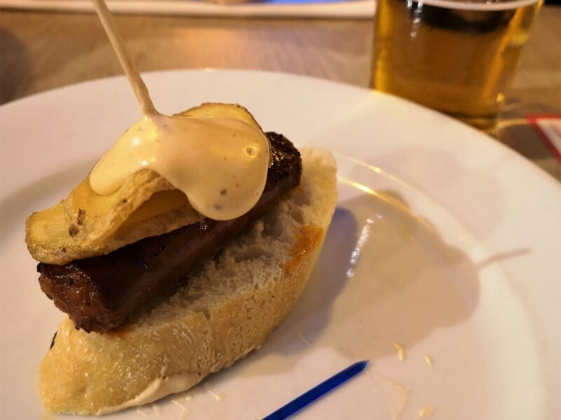 A pinxto with bread and sausage with a beer in Malaga city at one the best Malaga restaurants