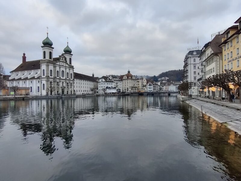 A view down the Reuss river with Lucerne's Old Town lining either side on a cloudy day