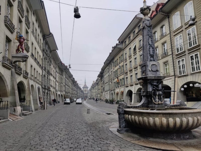 A view down one of the oldest and most popular streets in Bern Old Town with a large fountain for drinking